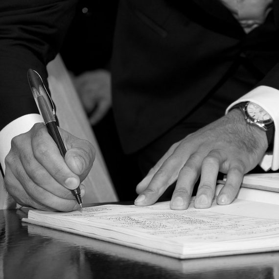 man signing a document in suit